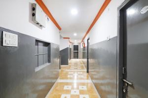 um longo corredor com piso em azulejo e uma porta em OYO Hotel 74966 Shree Amardeep Hotel em Hyderabad