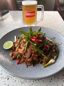a plate of food on a table with a glass of beer at Karma Traders Kampot in Kampot
