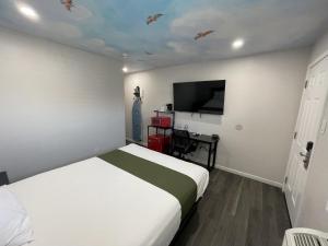 a bedroom with a bed and a flat screen tv at Fontana Inn in Fontana