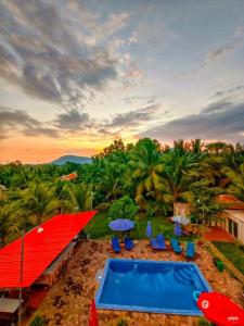 a resort with a red roof and a swimming pool at Karma Traders Kampot in Kampot