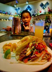 a plate of food on a table with a drink at Karma Traders Kampot in Kampot