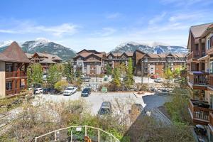 an apartment complex with a parking lot and mountains at ⭐️ Luxury Mountain View Studio in Canmore ⭐️ in Canmore