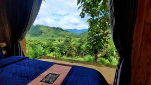 1 dormitorio con ventana y vistas a la montaña en Toong homestay, en Ha Giang