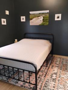 a bed in a bedroom with a black frame at Lupine Cabin - Homer Seaplane Base in Homer