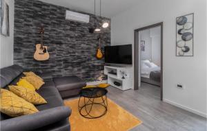 een woonkamer met een bank en een bakstenen muur bij 2 Bedroom Stunning Apartment In Jadranovo in Jadranovo