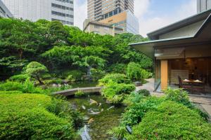 a garden with a pond in the middle of a building at ANA InterContinental Tokyo by IHG in Tokyo