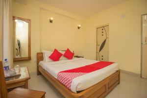 a bedroom with a large bed with red pillows at Capital O Hotel Red Cherry in Gangtok