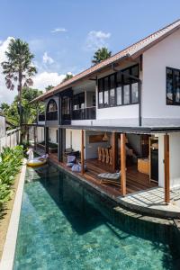 a house with a swimming pool next to a house at Villa Tamara Canggu Bali in Kerobokan