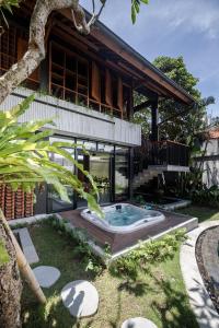 a house with a hot tub in the yard at Villa Tamara Canggu Bali in Kerobokan