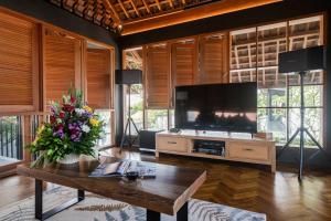 a living room with a large television and a table at Villa Tamara Canggu Bali in Kerobokan