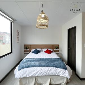 a bedroom with a bed and a chandelier at Andean Homes in La Paz
