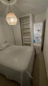 - une chambre avec un lit blanc et une lampe dans l'établissement Mitre, à Rosario