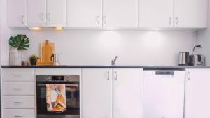 a white kitchen with white cabinets and an oven at Apartment 10 The Stables Perisher in Perisher Valley