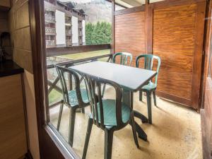 una mesa y sillas en un balcón con ventana en Studio Brides-les-Bains, 1 pièce, 4 personnes - FR-1-512-247, en Brides-les-Bains