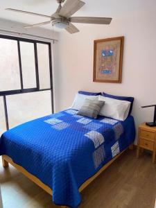 Schlafzimmer mit einem blauen Bett und einem Deckenventilator in der Unterkunft CENTRAL APARTMENT IN THE HEART OF MEXICO CITY in Mexiko-Stadt