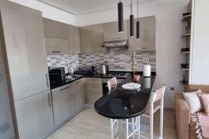 una pequeña cocina con mesa negra y sillas en Fantastique, luxerieux, agreabel appartement en Monastir