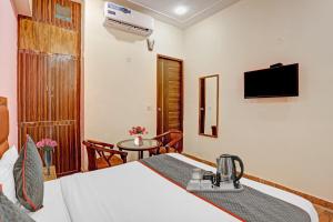大諾伊達的住宿－OYO Flagship 74435 Hotel Sharma，酒店客房配有一张床铺和一张桌子。