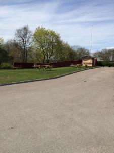 zwei Picknicktische und Bänke in einem Park in der Unterkunft Eskilstuna Hostel in Eskilstuna