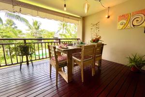 d'une salle à manger avec une table et des chaises sur un balcon. dans l'établissement Vaiava Beach Carlton- Tahiti - beachfront luxury residence & pool - 4 pers, à Punaauia
