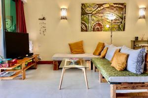 sala de estar con sofá y TV en Vaiava Beach Carlton- Tahiti - beachfront luxury residence & pool - 4 pers, en Punaauia