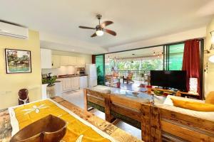 sala de estar con mesa y cocina en Vaiava Beach Carlton- Tahiti - beachfront luxury residence & pool - 4 pers, en Punaauia