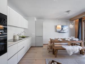een keuken en eetkamer met een houten tafel bij Appartement Megève, 5 pièces, 8 personnes - FR-1-569-31 in Megève