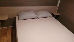 un letto con due cuscini sopra in una stanza di Mobil home Nature a Braucourt
