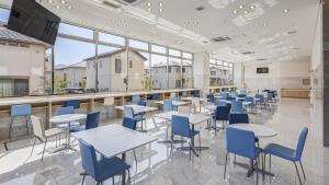 a cafeteria with tables and chairs and a bar at Toyoko Inn Imba Nihon-idai Ekimae in Inzai