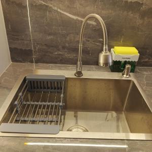 a kitchen sink with a dish drying rack in it at Free Shuttle Thamrin City Apartments at Nagoya with Netflix & Youtube Premium by MESA in Nagoya