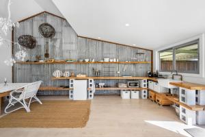 cocina con pared de madera y mesa en Molla Eco Lodge, en Wattamolla