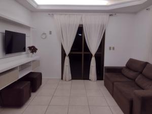 - un salon avec un canapé et une télévision dans l'établissement Leotel hospedagem, à Serra