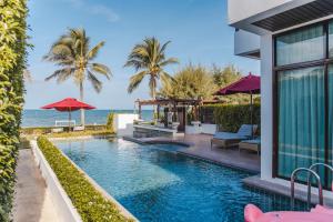 a resort pool with a view of the ocean at Tolani Le Bayburi Villas, Hua Hin - Pranburi in Pran Buri