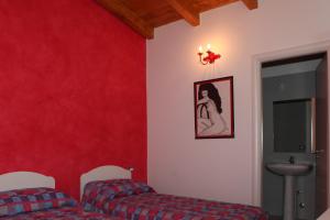 Habitación con 2 camas y pared roja. en Villa Monti Lepini, en Segni