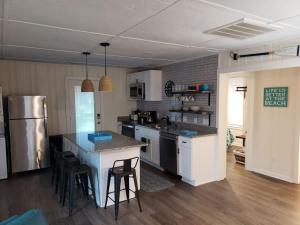 a kitchen with a counter and some chairs in it at Kure Beach Cottage-Fully Updated--1 block- welcome dogs for modest fee in Kure Beach