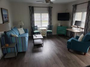 a living room with blue couches and a television at Kure Beach Cottage-Fully Updated--1 block- welcome dogs for modest fee in Kure Beach