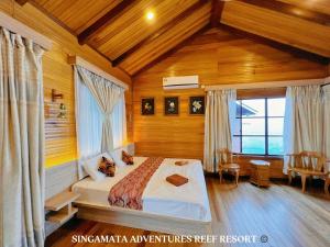 a bedroom with a bed in a room with wooden walls at Singamata Resort in Semporna