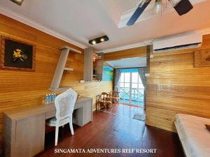 a kitchen with wooden walls and a table and chairs at Singamata Resort in Semporna