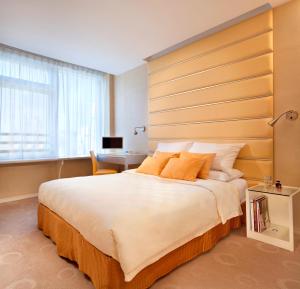 a bedroom with a large bed with a large wooden headboard at Cosmo Hotel Hong Kong in Hong Kong