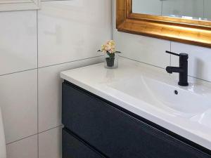 a bathroom with a sink and a vase of flowers at Holiday home Korssund III in Korssund
