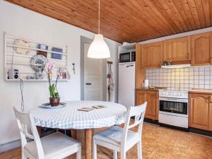 una cocina con mesa y sillas y una cocina con nevera blanca. en Holiday home Ærøskøbing XI en Ærøskøbing