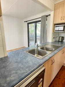 a kitchen with a sink and a counter top at Beach Shack in Bargara in Bargara