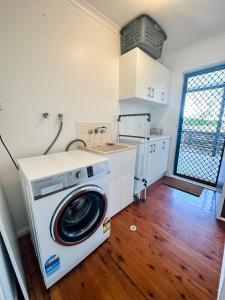 a washing machine in a kitchen with a sink at Beach Shack in Bargara in Bargara