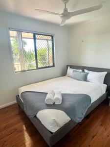 a bedroom with a large bed with two towels on it at Beach Shack in Bargara in Bargara