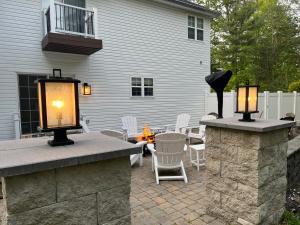 un patio con 2 luces y una mesa con sillas en Hot Tub-King Suite-Pet Friendly-Fenced Yard-Fire Pit-500Mbps-Fireplace, en East Stroudsburg