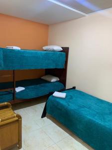 a room with two bunk beds with blue sheets at Hermoso Alojamiento in Choachí