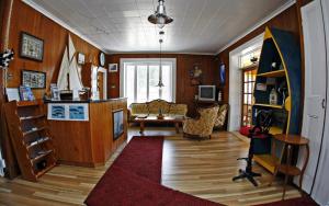 sala de estar con paredes de madera y alfombra roja en Hotel - Motel Georges, en Tadoussac