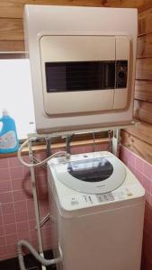 a microwave on top of a toilet in a bathroom at 一番館※温泉街に近く、心が落ち着く別荘地同樺順荘 in Kusatsu