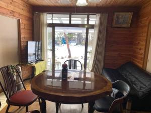 a living room with a wooden table and a couch at 一番館※温泉街に近く、心が落ち着く別荘地同樺順荘 in Kusatsu