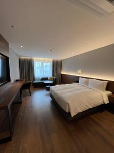 Habitación de hotel con cama grande y escritorio. en The Marevo en Suwon