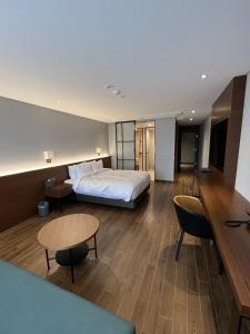 una camera d'albergo con letto, tavolo e sedie di The Marevo a Suwon